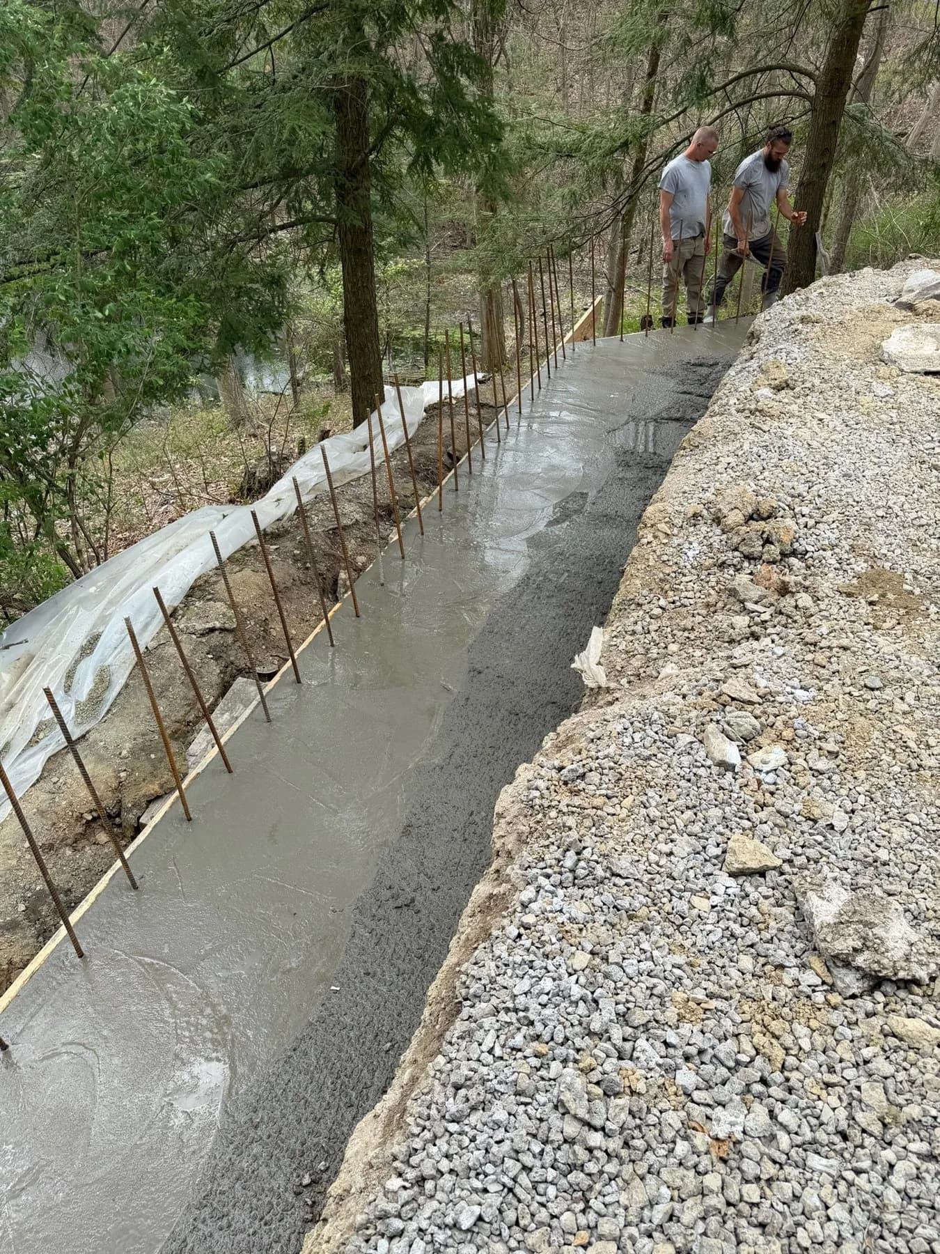 Poured concrete retaining wall with steel reinforcement in progress